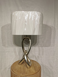 The Crestview Collection's ST. James Sculptural Knot Table Lamp has a twisted base, white shade, and wooden stand.