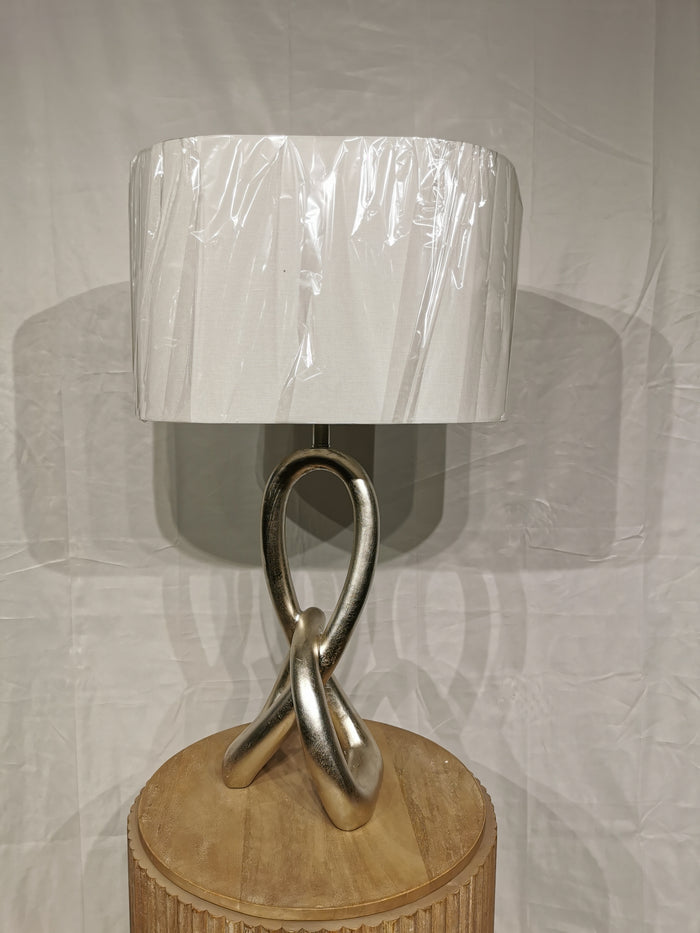 The Crestview Collection's ST. James Sculptural Knot Table Lamp has a twisted base, white shade, and wooden stand.