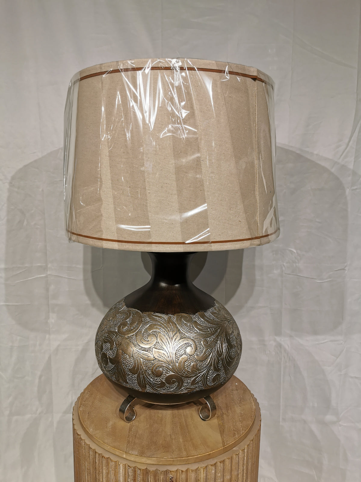 Crestview Collection's Silver Canyon Table Lamp features a bronze and silver resin base with a natural linen shade.