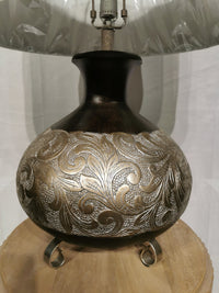 The Crestview Collection's Silver Canyon Table Lamp has a dark base with silver leaf and a natural linen shade.