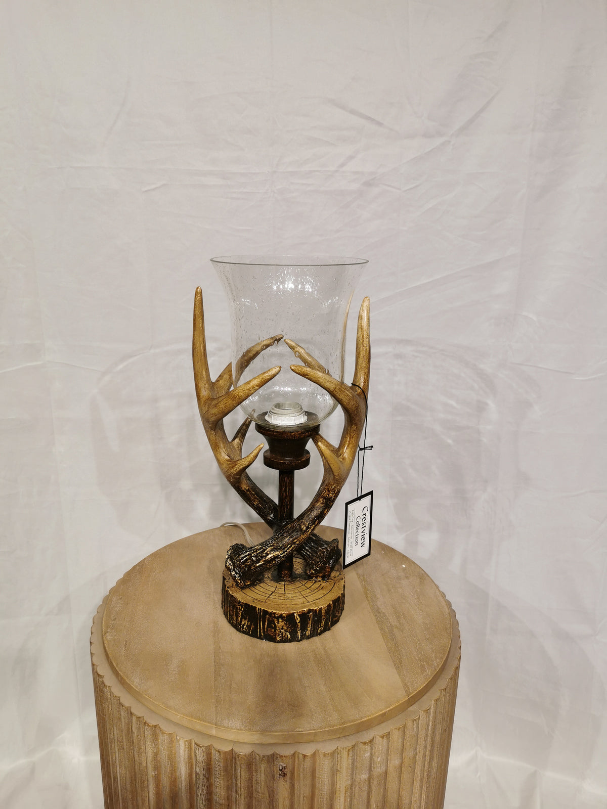 Crestview Collection's Huxley Antler Table Lamp adds a rustic touch on a round wooden table.