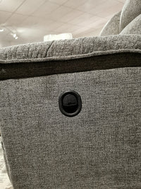 Close-up of the 706 Jay Loveseat by La-z-boy in gray, featuring a round black power outlet for personalized reclining.