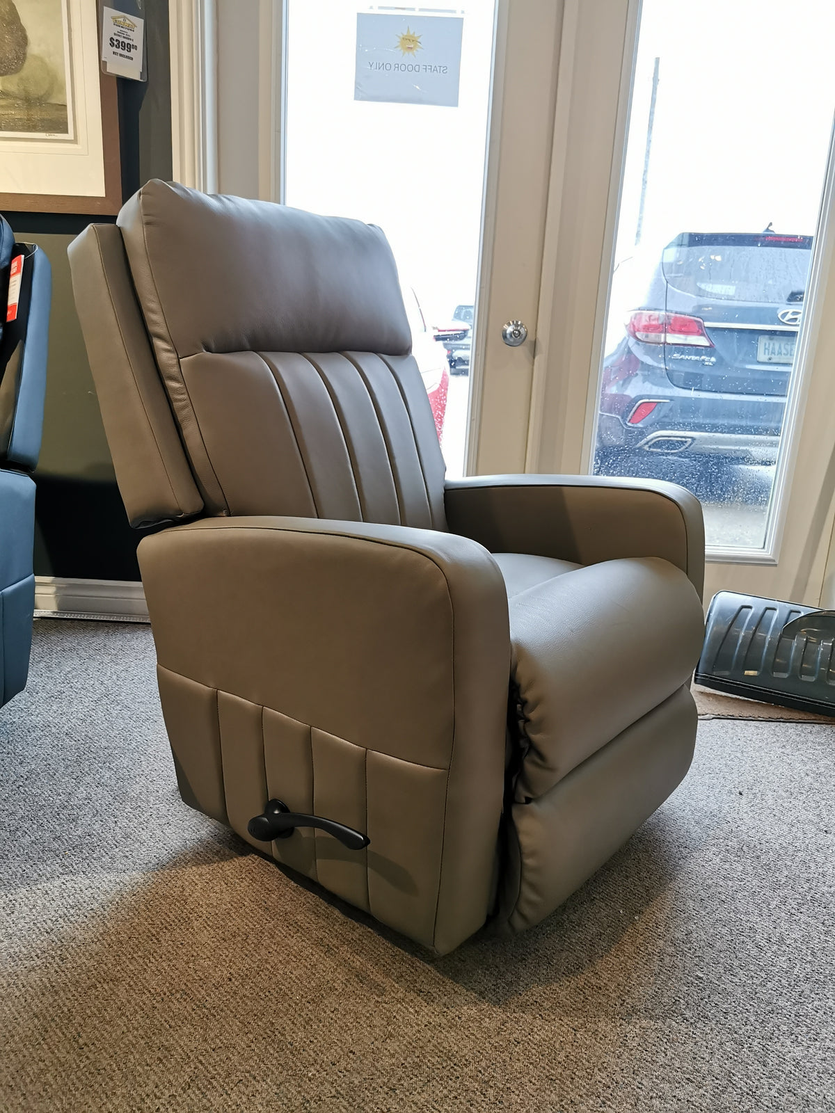 A La-Z-Boy 747-10 Finley Leather Rocker Recliner in a contemporary style sits near glass doors on a carpeted floor.