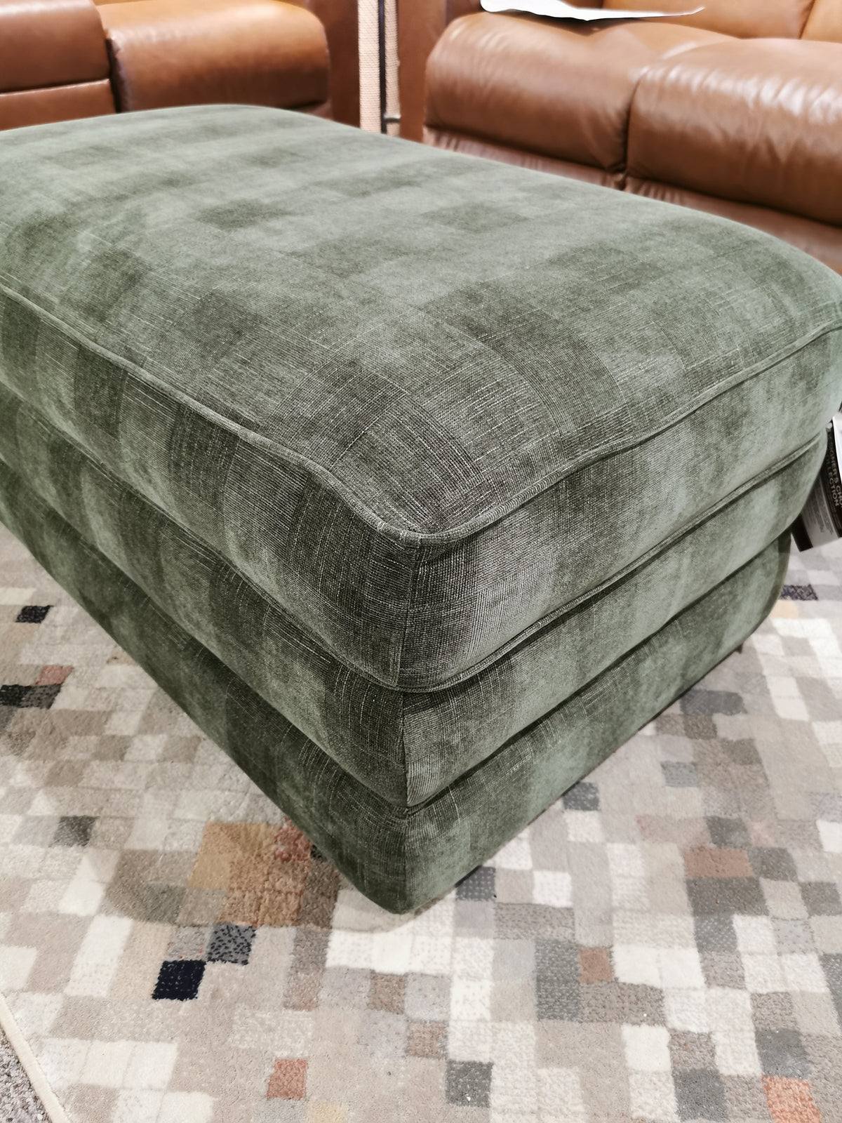 Cory 205 Storage Ottoman by La-z-boy on a patterned rug, paired with brown leather couches.