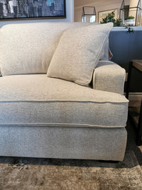 Corner of La-Z-Boy's beige 663 Paxton Chair & 1/2 with ComfortCore® cushion in living room, surrounded by plants and a rug.