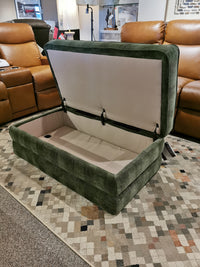 La-z-boy's Cory 205 Storage Ottoman in green sits open on a patterned rug, complementing brown recliners for added seating.