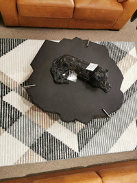 Mercana 69049 Shale Coffee Table with panther sculpture sits on a geometric rug between brown sofas.