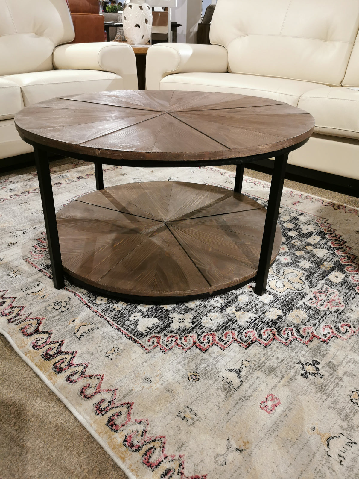 The Crestview Collection Jackson Round Coffee Table features a lower shelf, enhancing your living space with style and function.