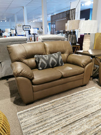 Brown Palliser 77343 Amisk loveseat with a patterned cushion on a beige carpet in a furniture showroom.