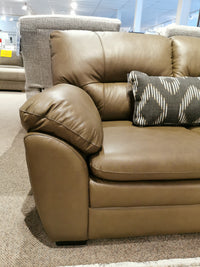 Amisk Loveseat by Palliser: Brown leather sofa with patterned cushion in a stylish store setting.