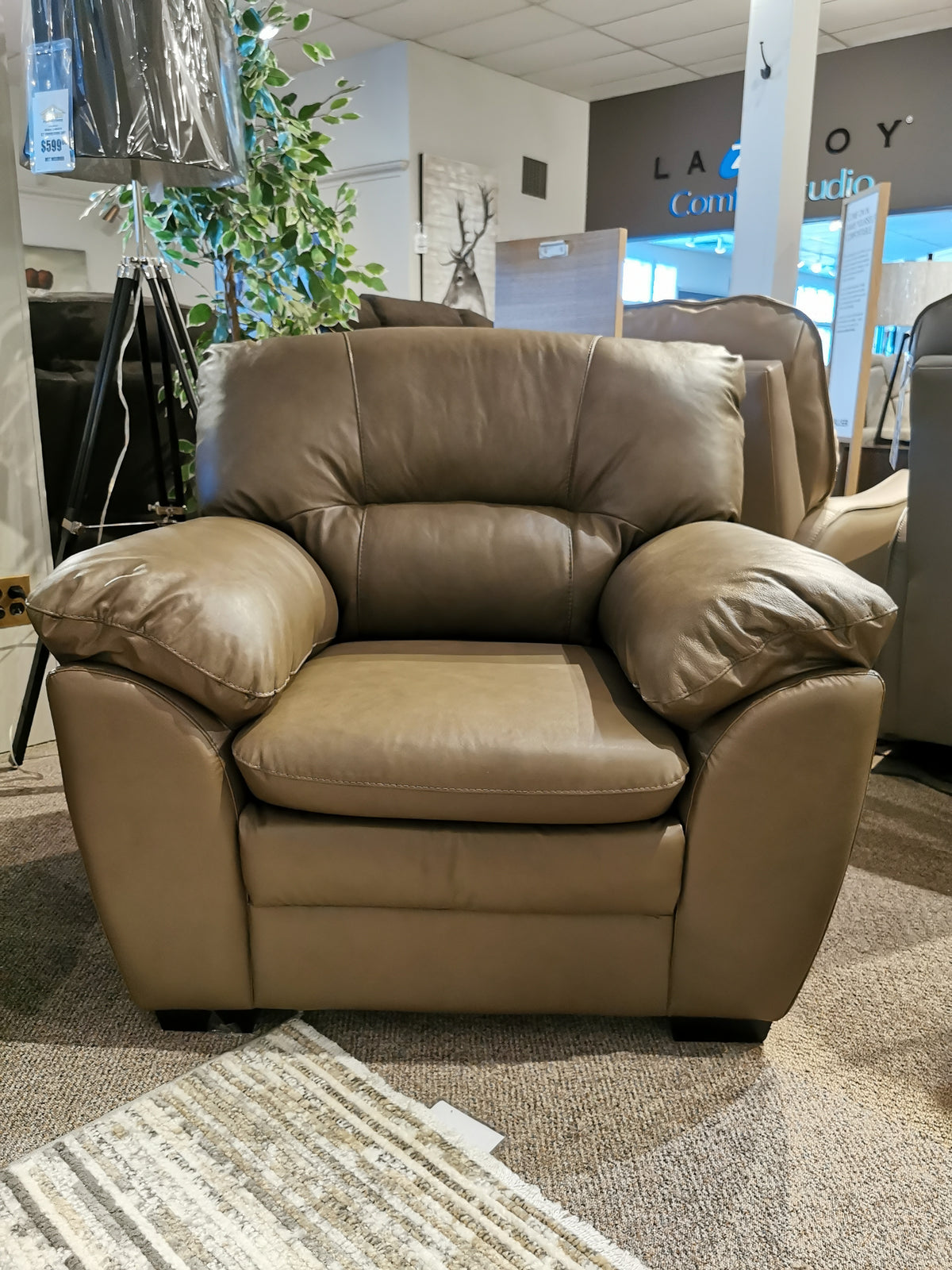 Palliser's 77343 Amisk Chair in brown leather on a carpeted floor in a lounge-like furniture showroom.