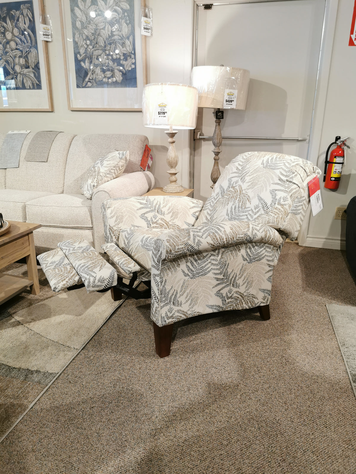 A La-Z-Boy 424 Fletcher Power Hi-Leg Recliner is displayed extended with a sofa and floor lamps in the store.