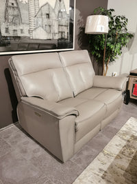 A Palliser Oakley Zero Gravity Power Loveseat in beige sits with a USB port, art, plant, and lamp in a living room.