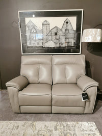 The Palliser 41187 Oakley Zero Gravity Power Loveseat is shown with farm-themed art and a floor lamp nearby.