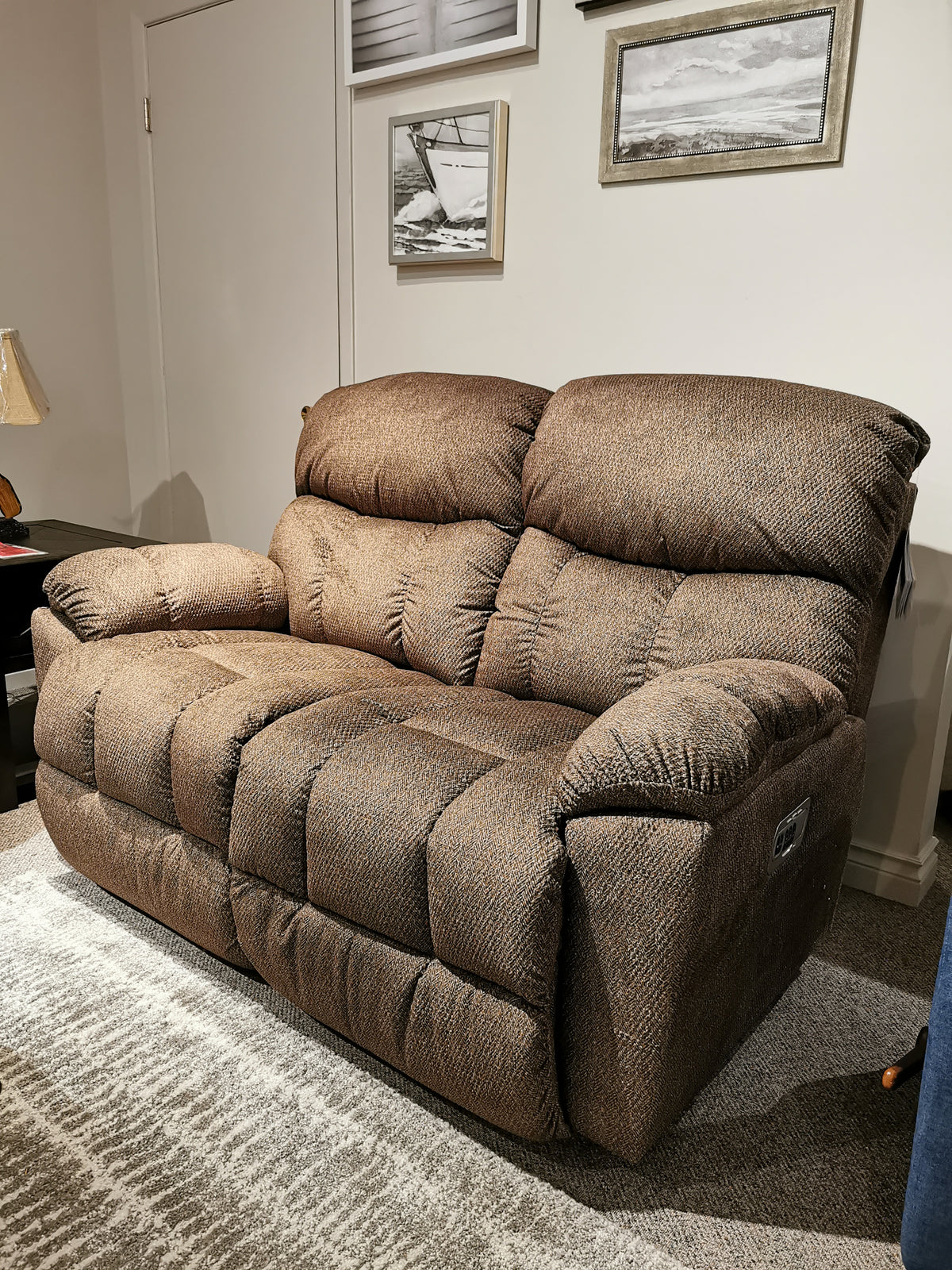 La-Z-Boy 766 Morrison Power Reclining Loveseat with adjustable legrests on a patterned rug, framed pictures adorning the wall.