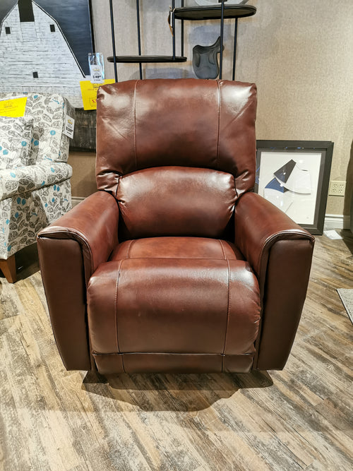 The 802 Cassian Rocker Recliner by La-z-boy, a brown leather chair made in America, is showcased on wooden floors.