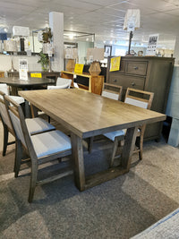 The showroom features the Donald Choi Winston Dining Package with rustic finish, 6 chairs, a dresser, and lamps.