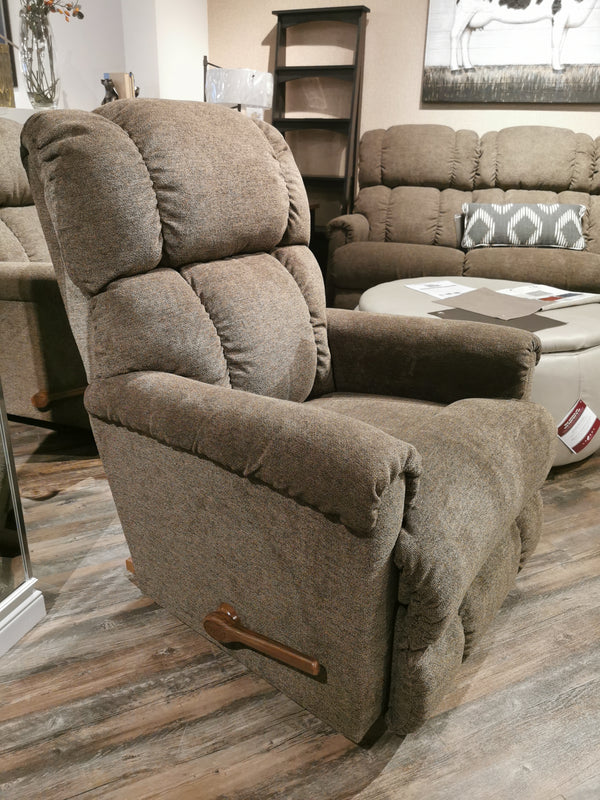 The La-Z-Boy 512 Pinnacle Rocker Recliner in brown, with a wooden lever, offers plush comfort on the showroom floor.