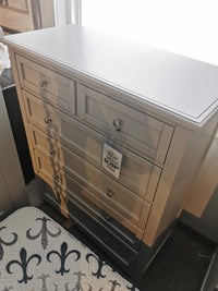 A Vaughan Bassett BB26115 Bonanza Grey 5 Drawer Chest, priced at $2,299, next to a patterned mattress.