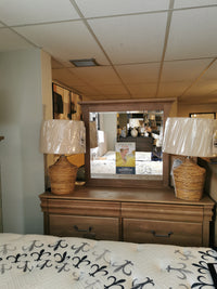 In a furniture showroom: Vaughan Bassett '771 Vista' dresser, Louis Philippe design, with mirror, lamps, and a bed.