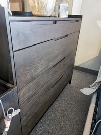 Hanson Charcoal Dresser by Donald Choi, a dark wood piece with five closed drawers, showcased in a showroom.