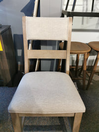 The Ashley D799 Moreshire Barstool's beige seat adds traditional elegance to any showroom.