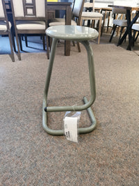 Discover Amisco's 44070-26 Paperclip Stool with metal frame, elegantly poised on a carpeted floor in a chic furniture store.