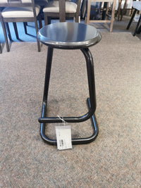 A limited-edition Amisco 44070-26 Paperclip Stool with a round seat and curved legs is on a carpeted floor in a store.