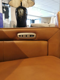 Close-up of a Timberland Power Sofa by Aurora Furniture in tan leather with power headrest in a stylish showroom.