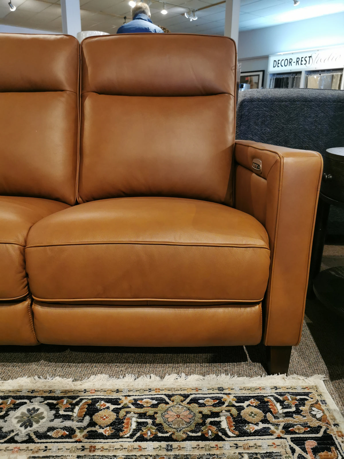 Timberland Power Loveseat from Aurora Furniture featuring a power headrest and armrests, resting on a patterned rug.