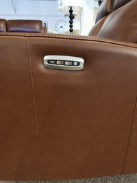 Close-up of the Muskoka Power Sofa by Aurora Furniture, featuring brown leather, moccasin stitching, and Zero Gravity function.