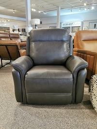 The Cascade Power Chair by Aurora Furniture, a gray leather recliner with a power headrest, is in the showroom.