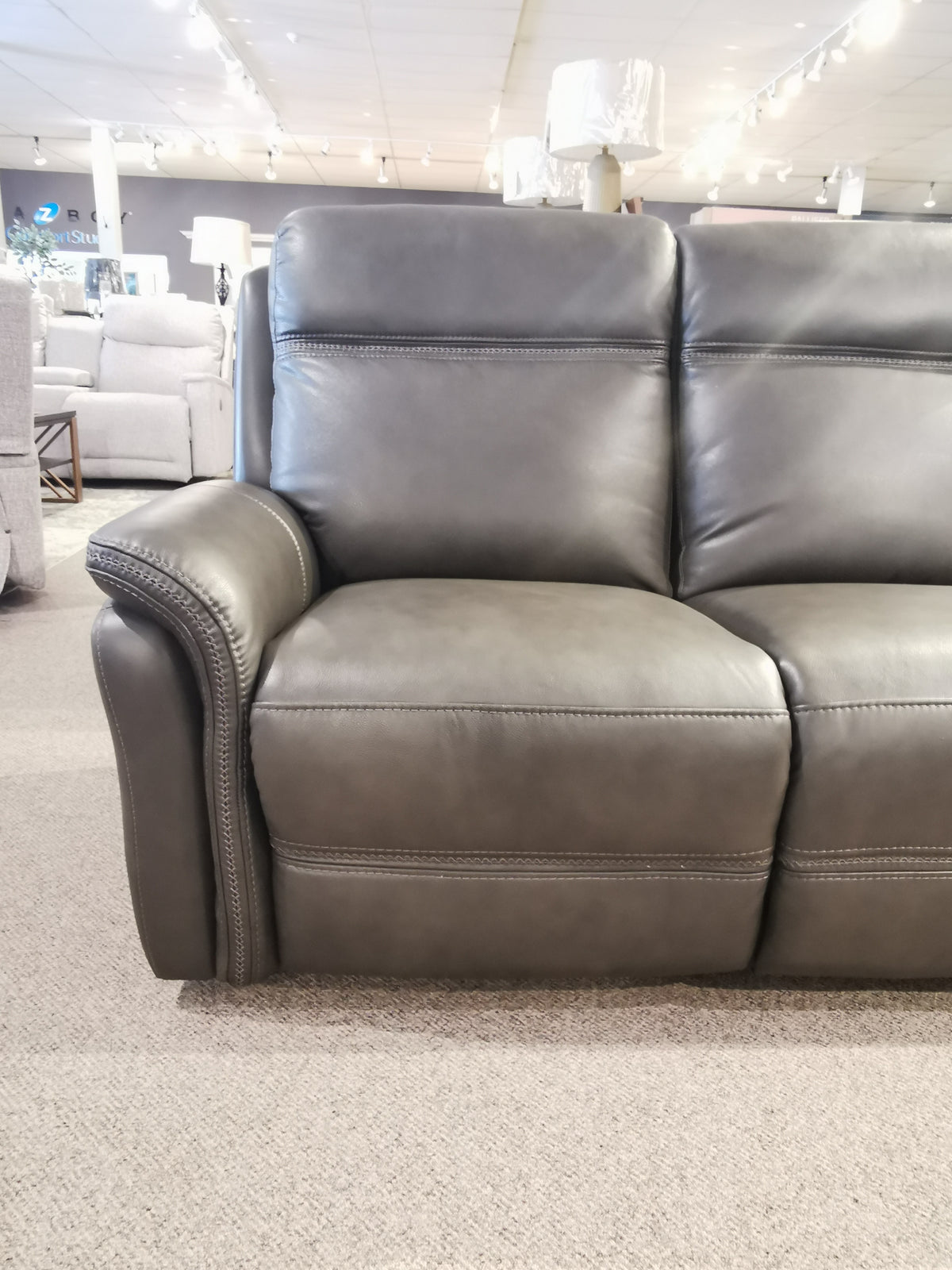 Cascade Power Sofa by Aurora Furniture: Dark gray leather with detailed stitching & overstuffed power headrest.