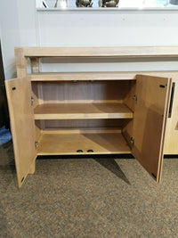 Somerset 64" Sideboard by Magnussen: Open wooden cabinet with graphite hardware, two doors, and a single shelf on carpet.