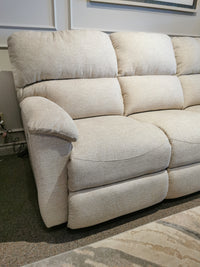 The La-z-boy 727 Brooks Power Reclining Sofa in beige offers comfort with cushioned armrests against a white paneled wall.