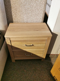 Vaughan Bassett's 830 2-Drawer Nightstand in solid American White Oak with metal handles on a natural tone textured carpet.