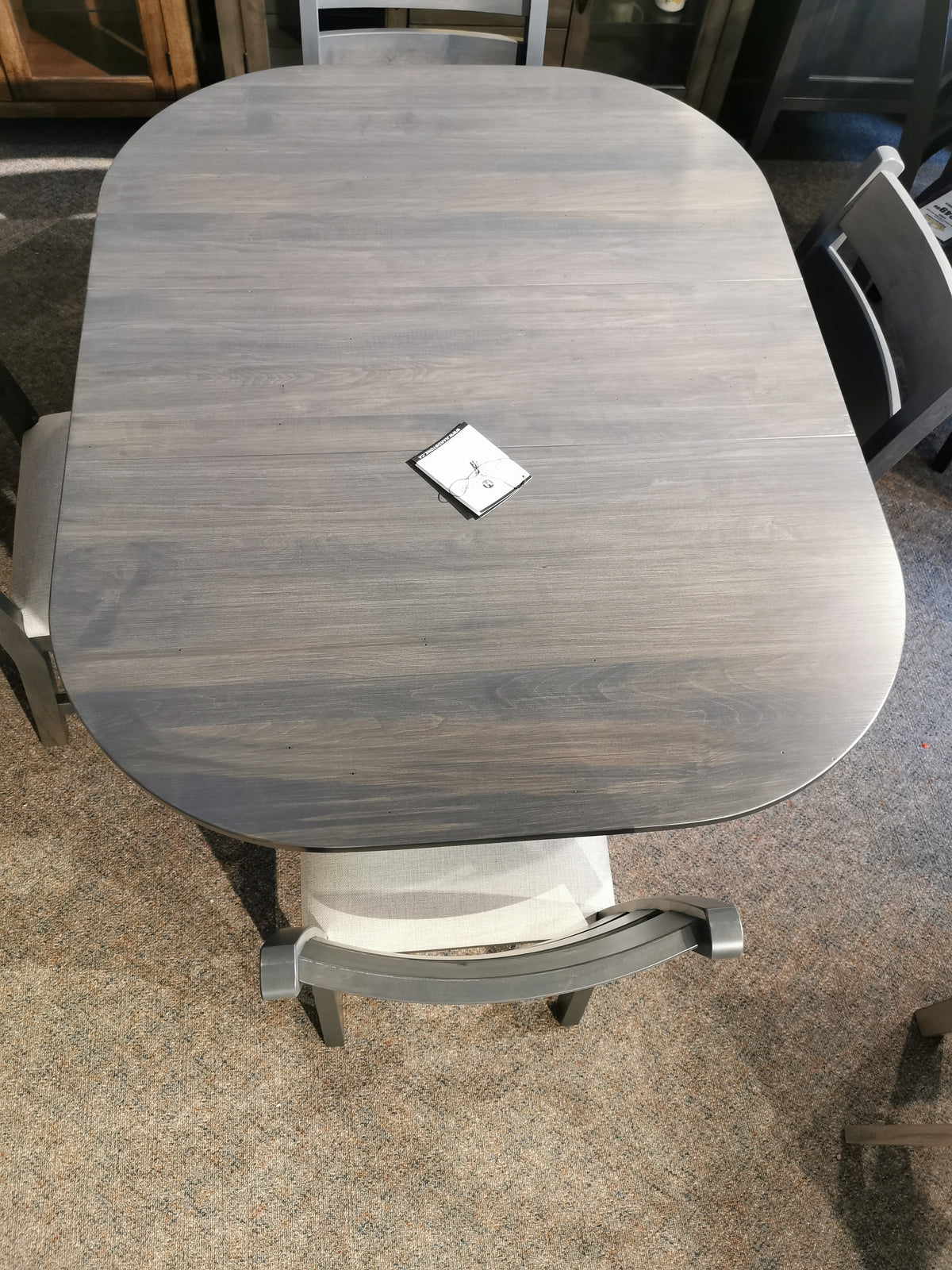 A Handstone Parker table with curved edges features a small square paper at its center.