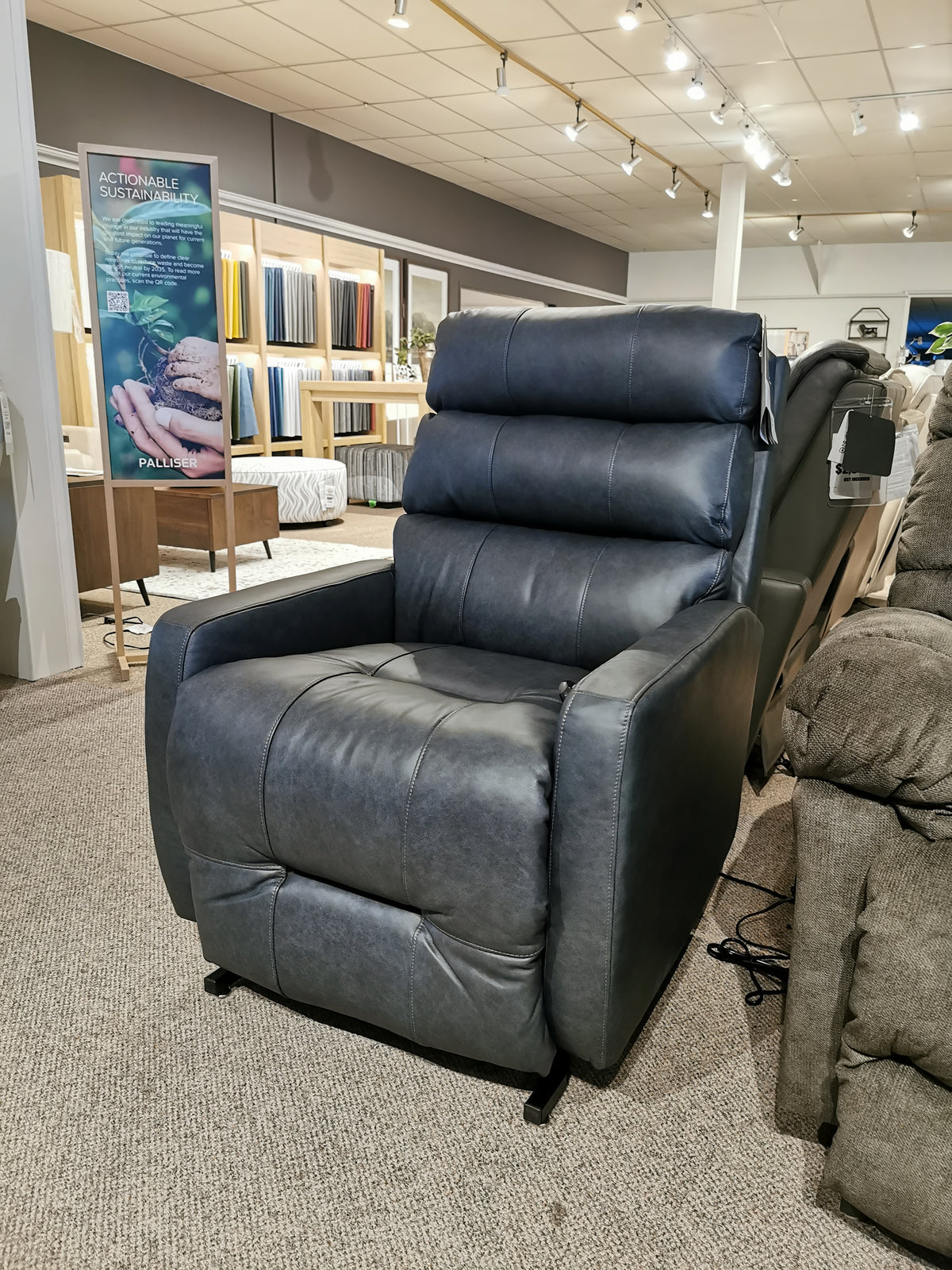 The Kristisha 9NZ31LV Power Lift Chair by Best is showcased, set against fabric samples in the showroom.