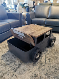 From Jofran's Glory Days Collection, the 2323 Vintage Car Coffee Table features a wooden lift-top on a rug between blue sofas.