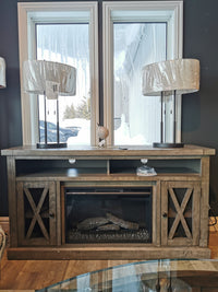 The Jofran Telluride Electric Fireplace Mantel adds coziness to your media area, nestled between snow-framed windows.