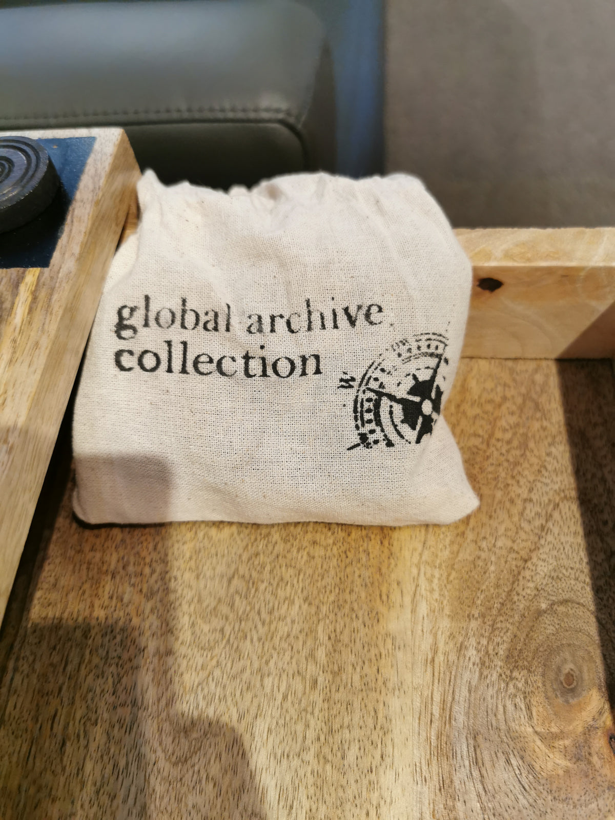 Natural materials shaped by expert artisans form a "Global Archive Collection" cloth bag on the Fairchild Checkerboard C-Table.