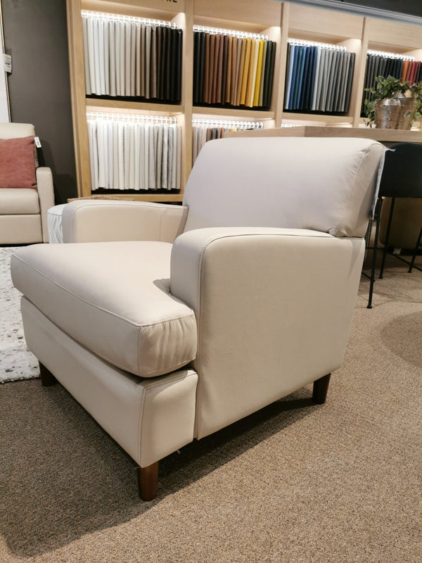 The showroom displays a light beige Palliser Abby 77108 Chair with fabric samples adorning the wall behind it.