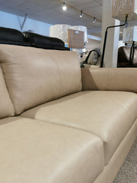 Close-up of a 77882 Payton Sofa in beige leather by Palliser, with minimalist decor in a furniture showroom.