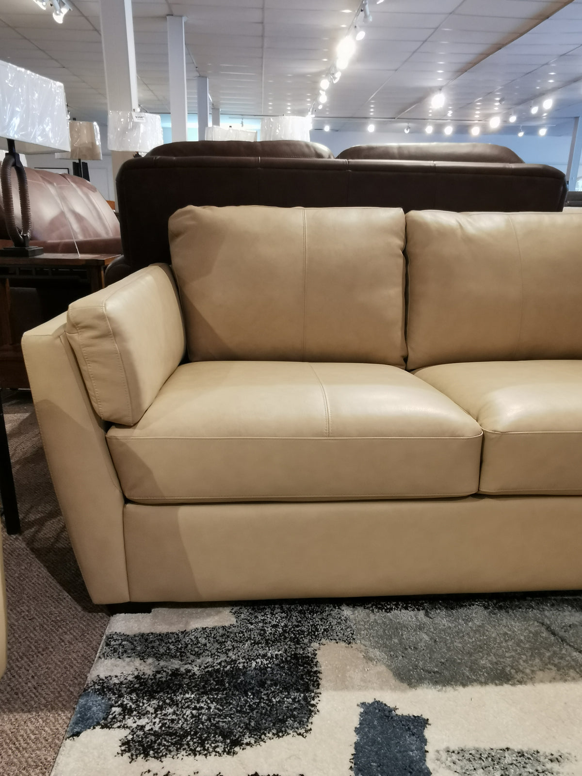 Palliser 77882 Payton Loveseat on showroom floor, with a patterned rug, showcases minimalist seating and transitional style.