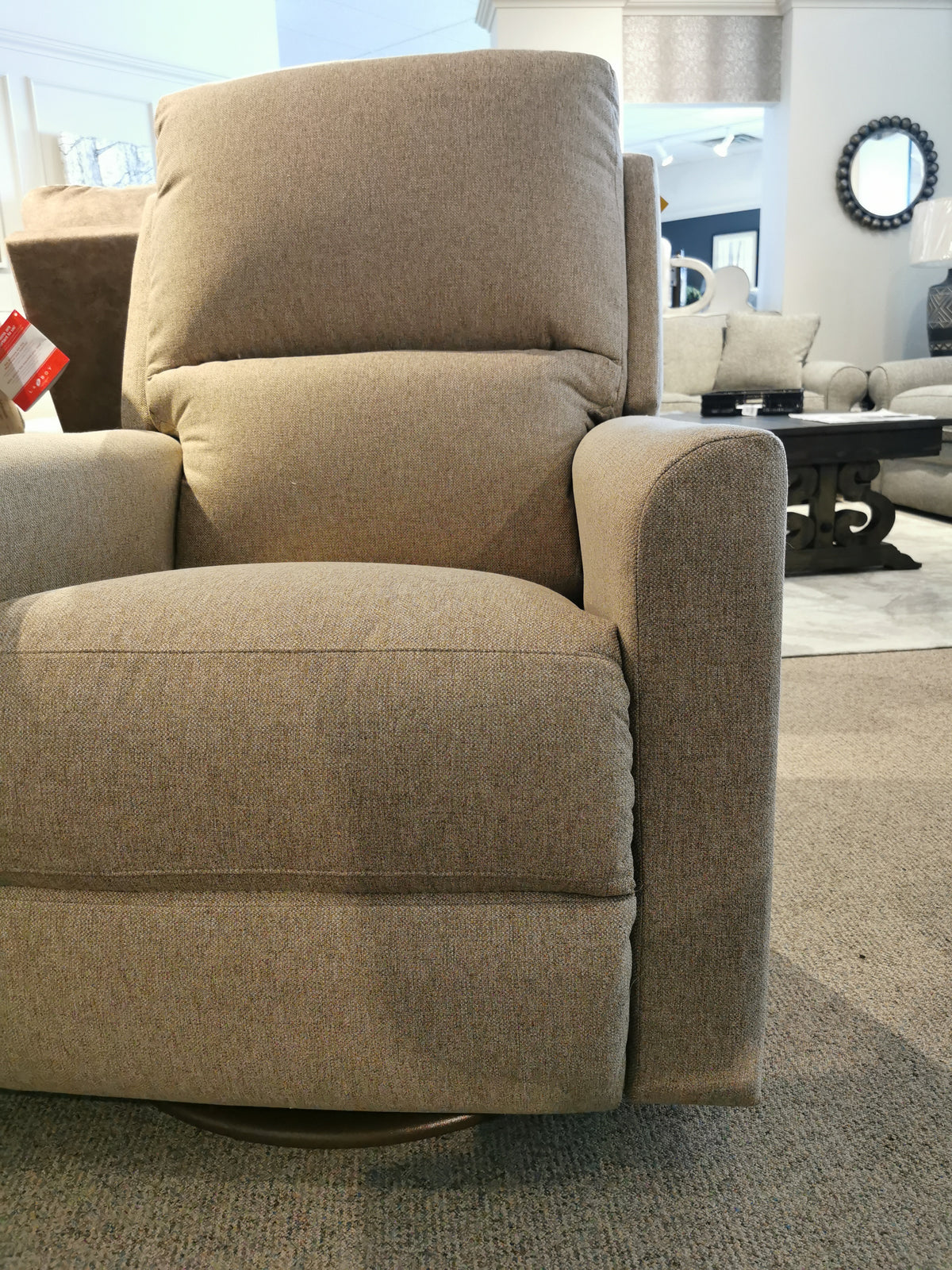 The La-Z-Boy 700 Wynne Swivel Glider in beige is showcased on a neutral carpet alongside other living space furniture.