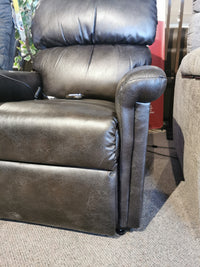 A plush black leather Austin UC-342 Power Lift Chair by Golden on carpet, with a seamed back and padded armrest.