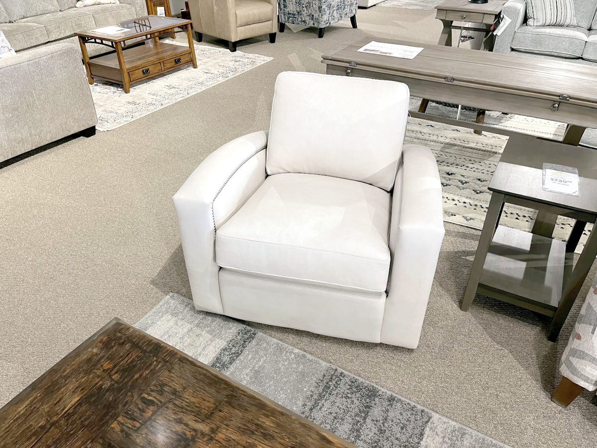 Leather Craft 741 Leather Swivel Chair on display with tables, chairs, and sofas in a carpeted showroom.