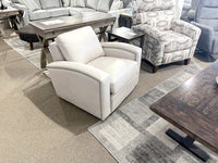 Leather Craft's 741 Leather Swivel Chair with studded detailing, displayed among various furnishings on a gray carpet.