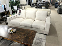 The Gravenhurst Leather Sofa by Leather Craft sits in the showroom, facing a wooden coffee table with a decorative bowl.