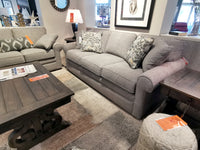 Furniture showroom featuring a La-z-boy 494 Collins Sofa, wooden coffee table, patterned rug, and decorative pillows.